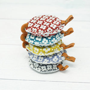 Cohana Yuzen Leather Tape Measure shown in a stack - red, green, yellow, blue, grey | Yarn Worx