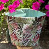 Fabric planter with floral pattern and pink flowers in the background