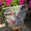 Fabric pouch with floral pattern on a small wooden stool with flowers in the background