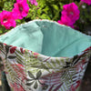 Fabric basket with floral pattern against a background of pink flowers