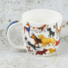 White mug with colorful dog illustrations on a textured gray background | Yarn Worx