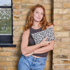 Woman holding a leopard print pouch against a brick wall | Yarn Worx