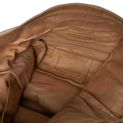 Close-up of a brown leather bag with a visible brand label on a white background | Yarn Worx