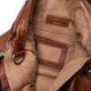 Close-up of a brown leather bag with visible stitching and a brand label | Yarn Worx