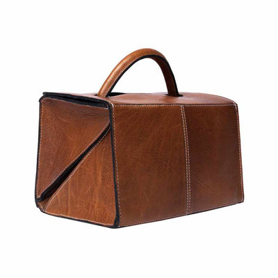 A brown leather project bag with a structured rectangular shape, a top handle, and diagonal panelling, shown on a plain white background | Yarn Worx