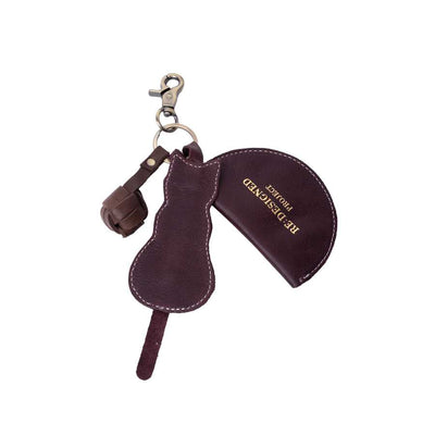 A dark burgundy leather accessory set featuring a curved snap-button pouch, a matching strap, and a metal clasp, displayed on a solid white background | Yarn Worx