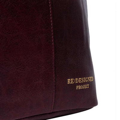 Close-up of a maroon leather fabric with 'RE: DESIGNED PROJECT' branding | Yarn Worx