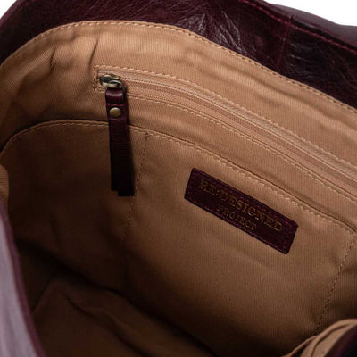 Close-up of a brown leather bag with a visible brand label | Yarn Worx