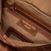 Close-up of a brown leather bag with 'RE-DESIGNED PROJECT' label.