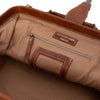 Close-up of the interior of a brown leather and canvas bag, showing a zippered pocket with a 'REDESIGNED PROJECT' label, a blank patch on the leather trim, and a tan fabric lining | Yarn Worx