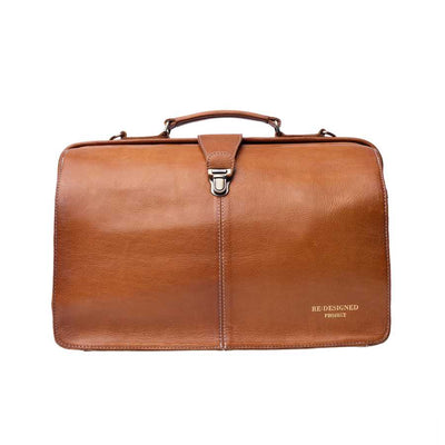 A tan brown leather doctors stylebag buckle, shown against a plain white background. The bottom right corner features the text 'RE-DESIGNED PROJECT' | Yarn Worx