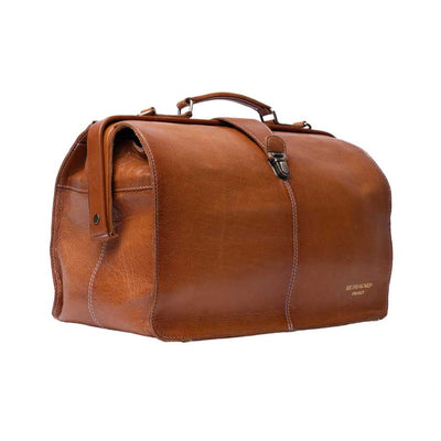 A brown leather doctors style bag with a top handle, and a small gold 'REDESIGNED PROJECT' logo on the lower right corner, shown against a plain white background | Yarn Worx