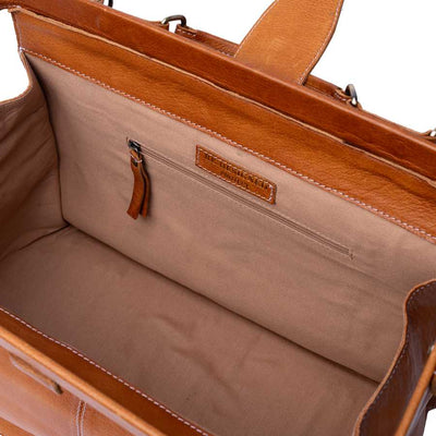Close-up of the interior of a tan leather bag, showing a beige fabric lining, a zippered pocket, and a small leather brand patch that reads 'REDESIGNED PROJECT' | Yarn Worx