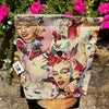 Decorative pouch with artistic designs of women and flowers on a stand with pink flowers in the background