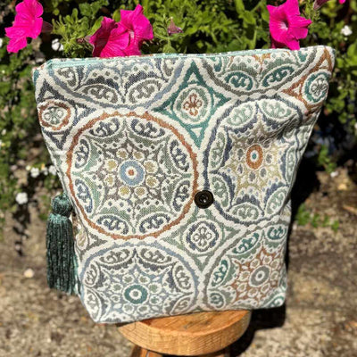Decorative pillow with a geometric pattern on a stand with pink flowers in the background