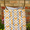 Patterned bag with a brick wall and flowers in the background