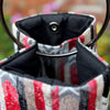 Close-up of a plaid-patterned bag with a black interior and metal clasp.