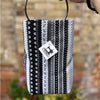 Black and white patterned bag held by a person with a blurred background