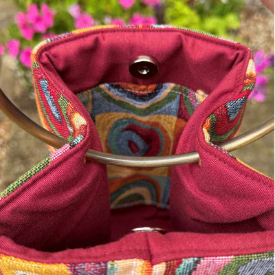 Close-up of a colorful embroidered bag with a floral background