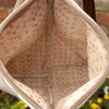 Close-up of a beige fabric bag with a subtle pattern, blurred outdoor background