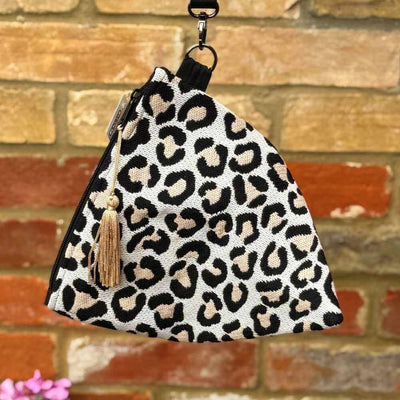 Leopard print pouch with tassel on a brick wall background