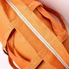 Close-up of an orange bag with a zipper on a light background | Yarn Worx