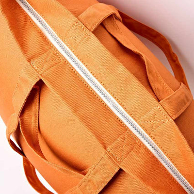 Close-up of an orange bag with a zipper on a light background | Yarn Worx