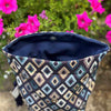 Patterned fabric bag with pink flowers in the background