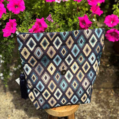 Patterned pouch on a stool with pink flowers in the background