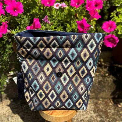 Patterned bag on a stand with pink flowers in the background
