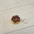 Donut-shaped keychain with chocolate glaze and sprinkles on a light wooden surface