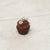 Small keychain shaped like a chocolate cupcake with a brown top on a light beige surface.