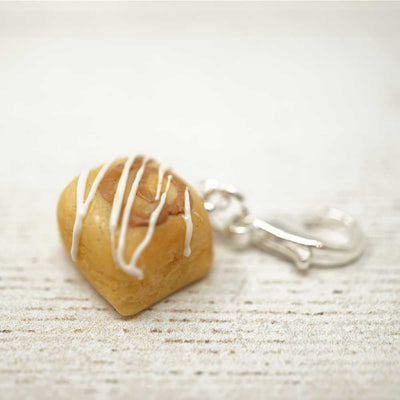 Heart-shaped keychain with white drizzle on a light wooden surface