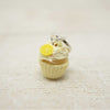 Cupcake-shaped keychain with lemon on a light wooden surface