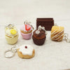 Set of miniature dessert keychains on a textured surface