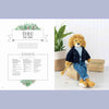 Knitted lion toy named Theo sitting on a woven box with plant and basket in the background | Yarn Worx