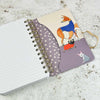Notebook with spiral binding and a cover featuring cartoon dogs on a textured surface | Yarn Worx