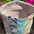 Close-up of a fabric pouch with a geometric pattern and gray interior.