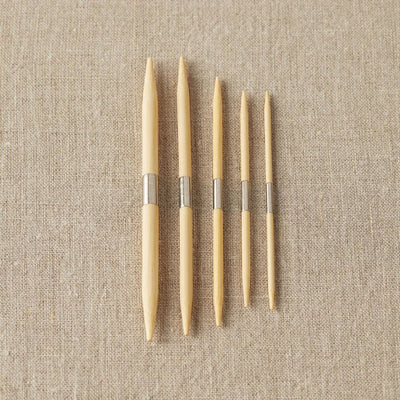 Cocoknits - Bamboo Cable Needles shown with all 5 needles laid on a cloth | Yarn Worx